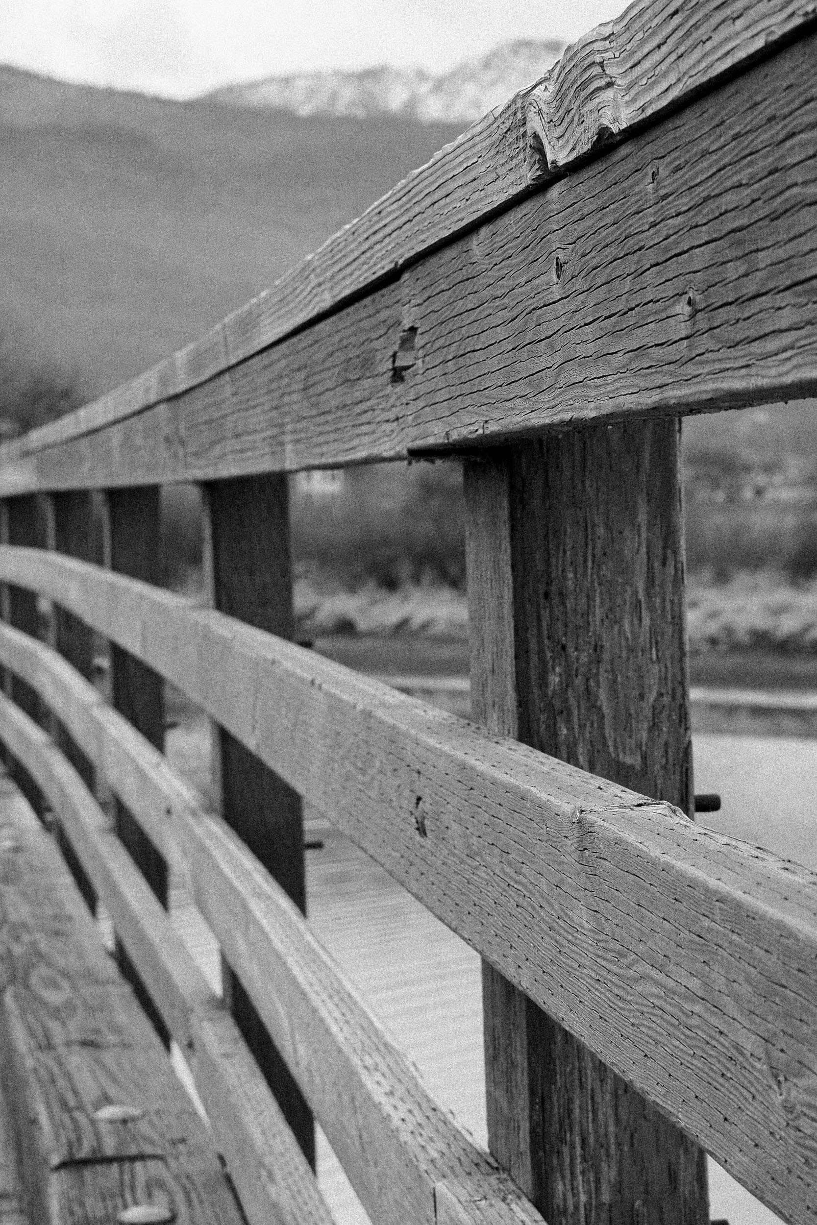 Weathered wooden railings lead across a bridge.