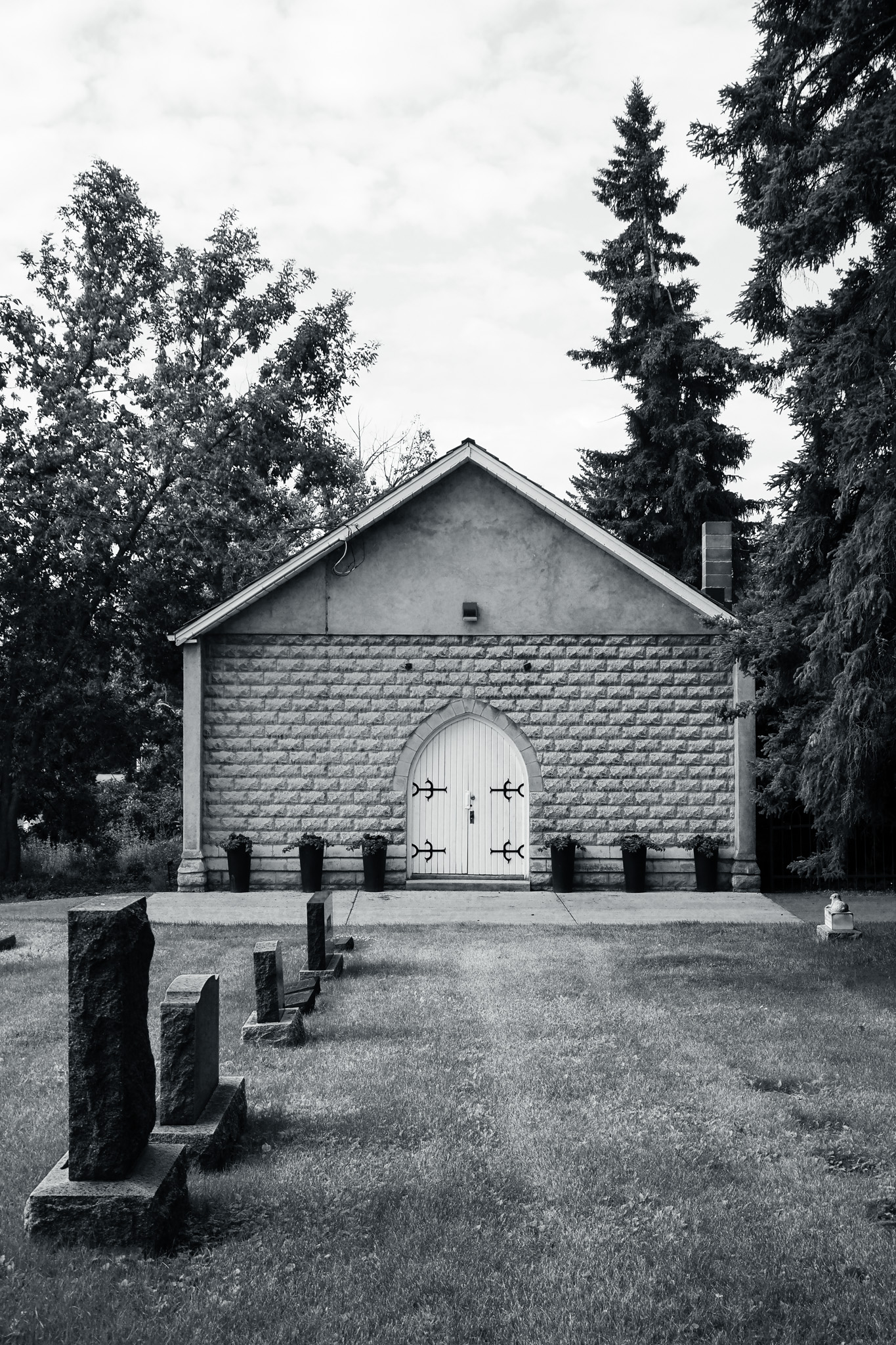 A small arched door sits in the wall of a modest building.